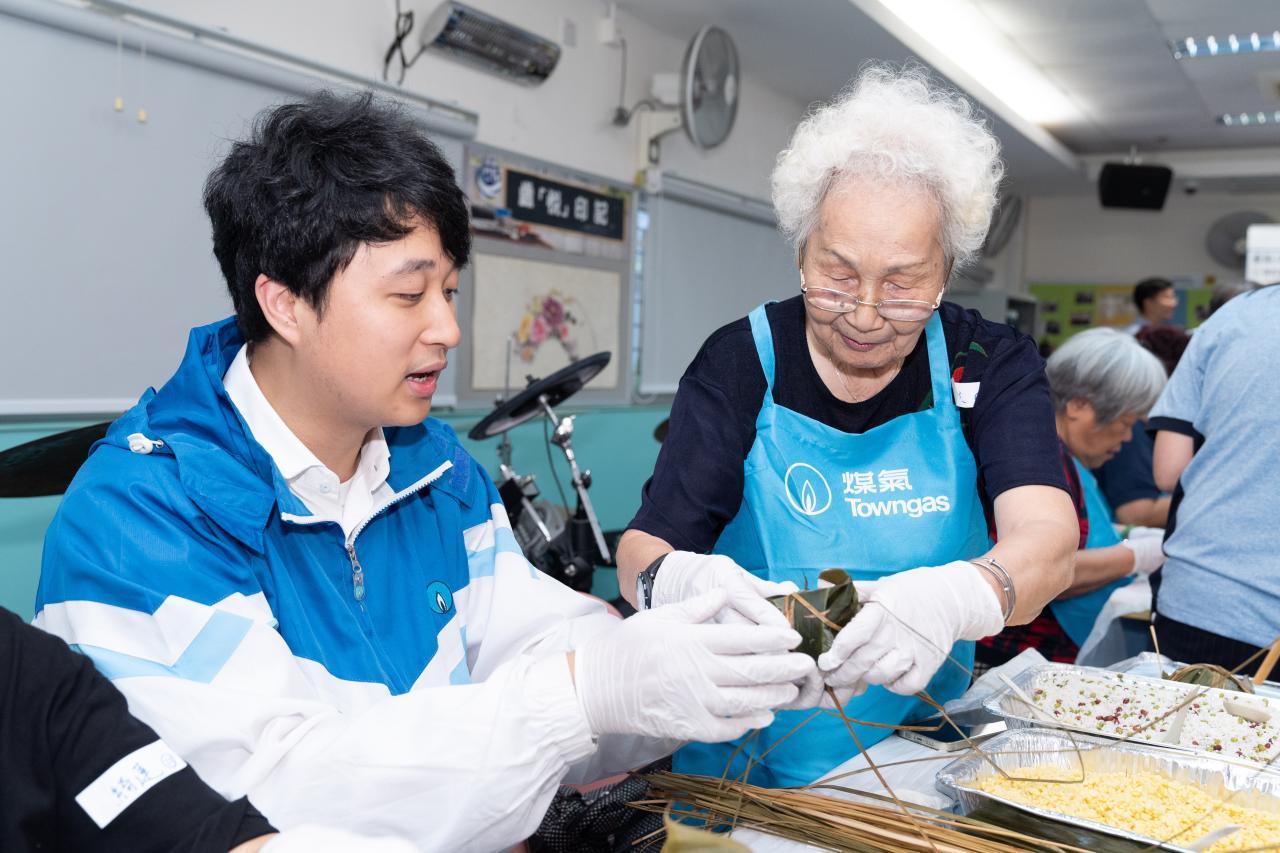  陳婆婆（右）認為包糉活動很有趣，感謝義工耐心陪伴。